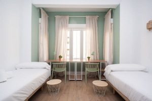 Habitación doble con dos camas y escritorio en el edificio Baltasar Gracián 9.